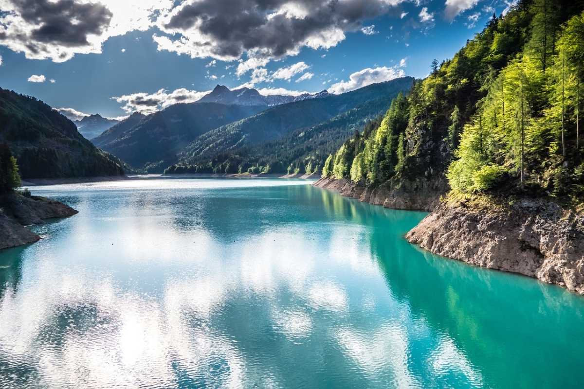 Vista panoramica di Sauris con montagne sullo sfondo e il lago alpino in primo piano