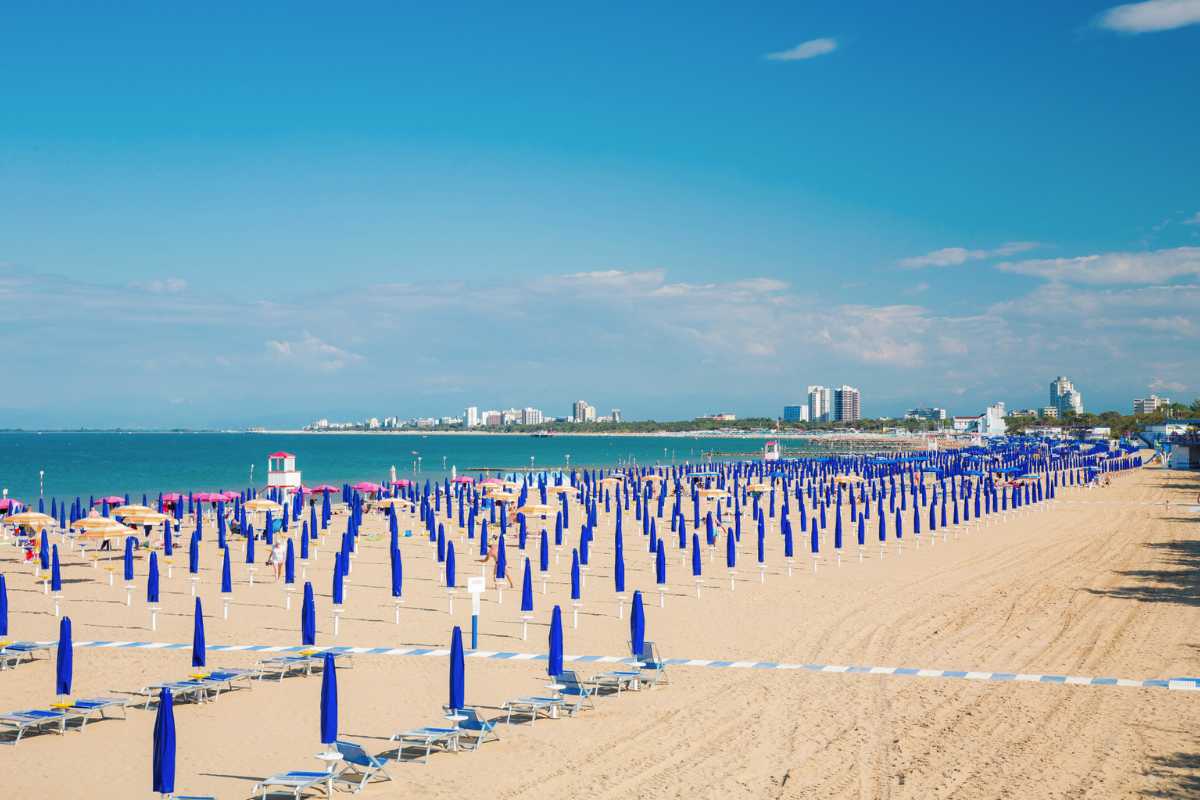 Vista panoramica della spiaggia di Lignano Sabbiadoro, con ombrelloni e bagnanti